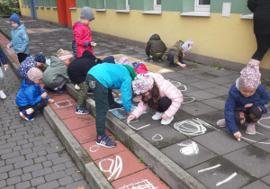 Dzieci malują kredą.